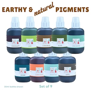 May include: Nine 30ml bottles of earthy and natural pigments are displayed. Colours include Chocolate, Avo, Cinnamon, Olive, Zen Green, Ocean, Sunkissed, Duck Egg, and Latte. Each bottle features "Home Ware Design" branding. The text "Set of 9" is also visible.