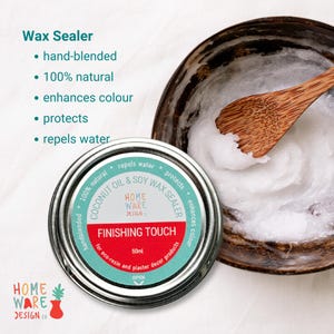 May include: A 50ml tin of coconut oil and soy wax sealer labeled "Finishing Touch" by Home Ware Design. The label is teal and red with white text. The tin is open and the wax sealer is white and creamy.