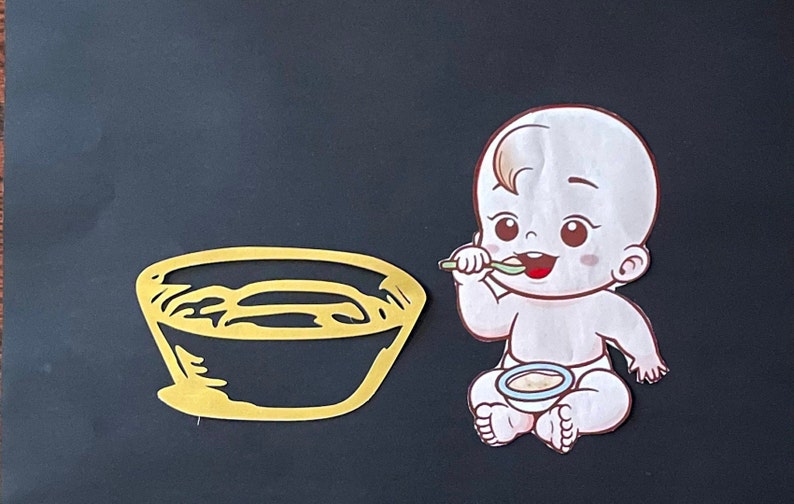 May include: A yellow bowl with a white interior and a cartoon baby holding a spoon and eating from a blue bowl.