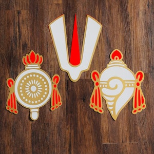 May include: Three decorative wall hangings with a white and gold design. The center hanging is a stylized Om symbol with a red accent. The two side hangings are stylized bells with red accents.