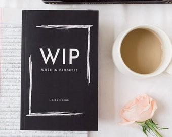 May include: A black book with a white square frame around the text "WIP WORK IN PROGRESS" and the author's name "MOIRA E KING".
