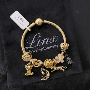Linx Yellow Gold Snake Chain Bracelet with Black and Gold Charms