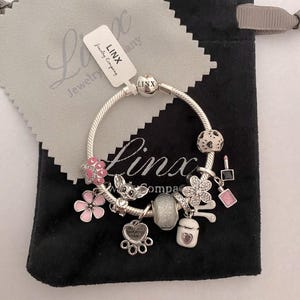 Pulsera de plata de ley con dijes: flor rosa, huella de pata y petauro del azúcar