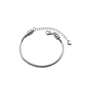 May include: A silver-colored bracelet with a snake chain design. The bracelet has a lobster clasp closure and an adjustable chain with a small heart charm. The bracelet is made of a shiny, metallic material.