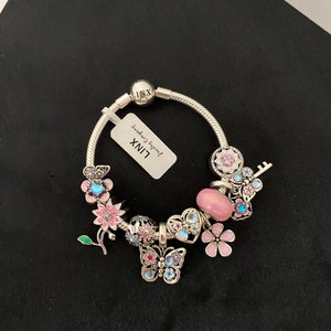 紫と銀の蝶と花をテーマにしたチャームが付いたパンドラブレスレット