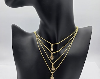 May include: Four gold necklaces with different pendant styles. The pendants are a teardrop, a heart, a circle, and a flower. All pendants have clear stones.