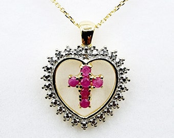 May include: A gold heart-shaped pendant necklace with a ruby cross inside. The heart is surrounded by small diamonds.