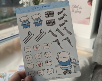 Könnte beinhalten: Ein Bogen Sticker mit einem Cartoon-Bärenzahnarzt in blauer Uniform und weißer Gesichtsmaske. Die Sticker zeigen verschiedene Zahnarztinstrumente, Zähne und einen Zahnarztstuhl. Der Text "Toof Things" befindet sich oben auf dem Bogen. Der Text "Design by @vitamin.xi." befindet sich unten auf dem Bogen.