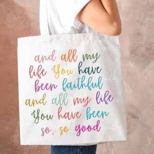 May include: A white canvas tote bag with the text "and all my life you have been faithful and all my life you have been so, so good" printed in rainbow colors.