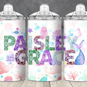 May include: Three white tumblers with clear lids and handles. Each tumbler features a different mermaid-themed design with a colorful, glittery name "Paisley Grace" on the middle tumbler.