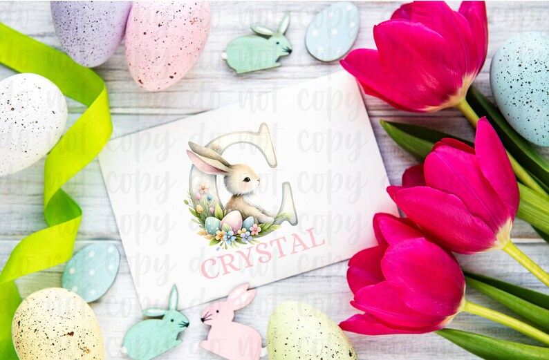May include: A white card with a pink bunny rabbit inside a letter C. The letter C is surrounded by pastel colored Easter eggs and flowers. The card says "CRYSTAL" in pink letters.