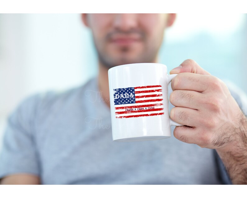 May include: White ceramic mug with a red, white, and blue American flag design. The text "DADA" is printed above the flag, and the names "Charlie, Claire, & Syra" are printed below the flag.