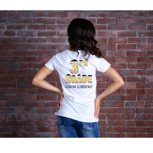 May include: White t-shirt with a yellow and pink graphic that says "3rd Grade Glenvar Elementary".