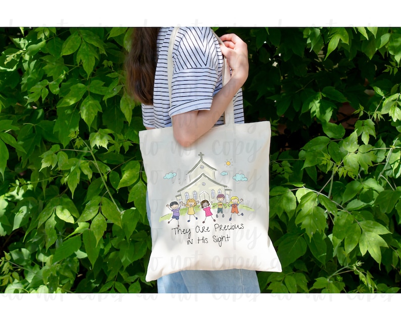 May include: A white canvas tote bag with a colorful illustration of children walking towards a church building. The text "They Are Precious In His Sight" is printed below the illustration.