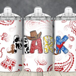 May include: Three white tumblers with red and white paisley patterns. The tumblers have clear lids and handles. The middle tumbler has the name "MARK" spelled out in colorful letters with cowboy-themed embellishments.