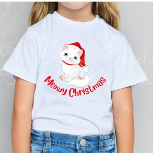 May include: White t-shirt featuring a cartoon cat wearing a Santa hat and a red collar. The cat is sitting and smiling, with the words "Meowy Christmas" in red script below. A festive holiday tee.