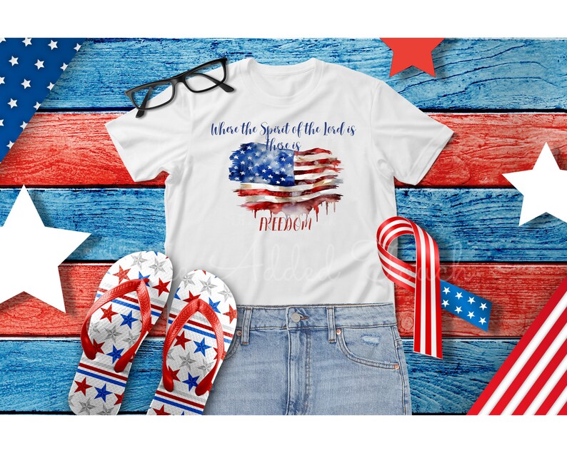 May include: White t-shirt with a watercolor American flag design and the text "Where the Spirit of the Lord is there is FREEDOM".