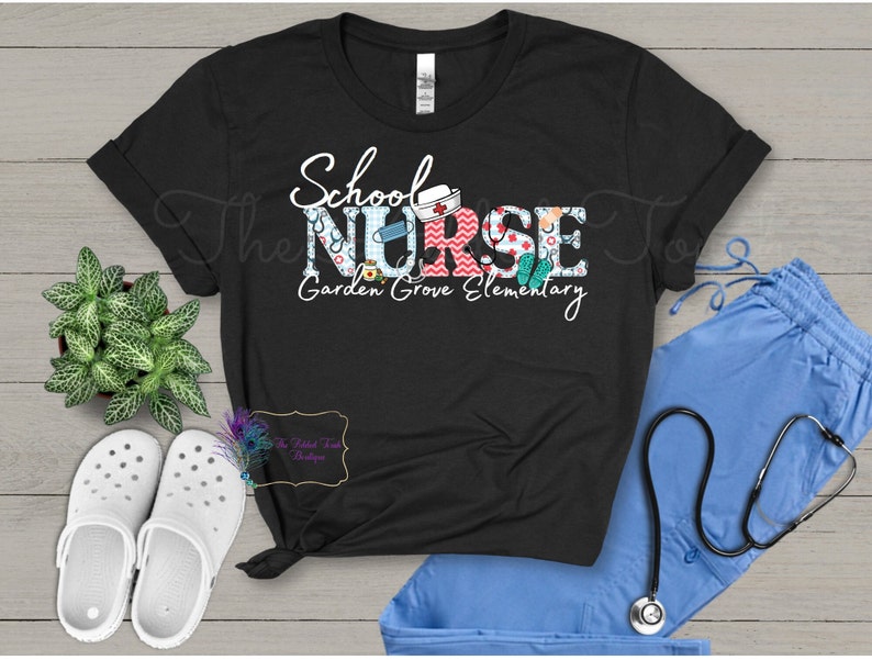 May include: Black t-shirt with the text "School Nurse" in colorful letters with medical and school-themed graphics. The text "Garden Grove Elementary" is below the main text.
