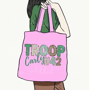 May include: Pink tote bag with the text "TROOP Carly #42" in green and brown patchwork letters.