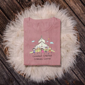 May include: A pink t-shirt with a cartoon illustration of a church and children. The text "Covenant Christian Childcare Center" is printed below the illustration.