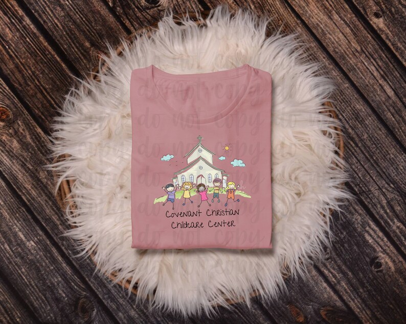 May include: A pink t-shirt with a cartoon illustration of a church and children. The text "Covenant Christian Childcare Center" is printed below the illustration.