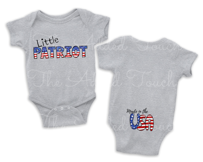 May include: A grey baby onesie with the text "Little PATRIOT" in red, white and blue on the front. The back of the onesie has the text "Made in the USA" in red, white and blue.