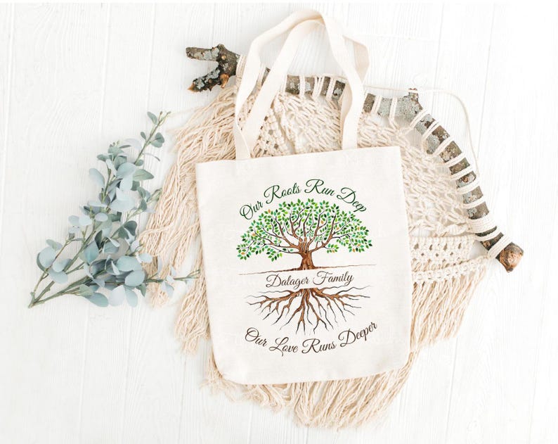 May include: A white canvas tote bag with a green tree design and the text "Our Roots Run Deep Dalager Family Our Love Runs Deeper".