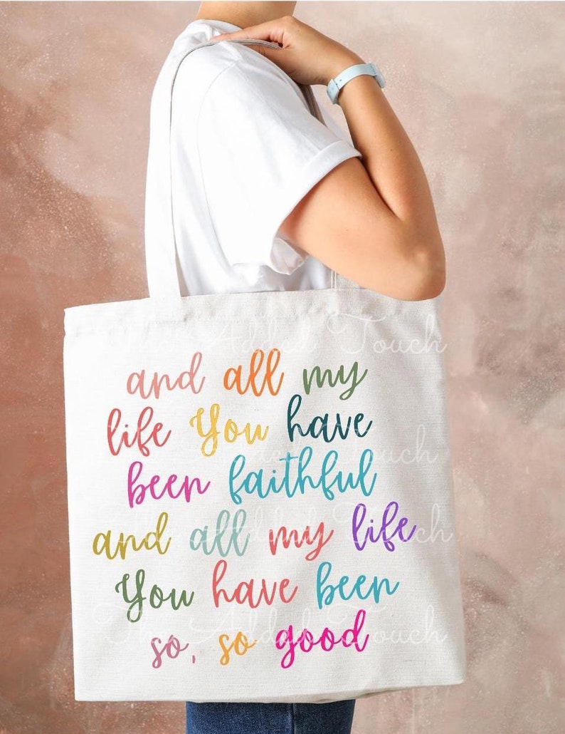 May include: A white canvas tote bag with the text "and all my life you have been faithful and all my life you have been so, so good" printed in rainbow colors.
