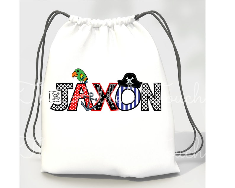 May include: White drawstring bag with a pirate-themed design featuring the name "Jaxon" in colorful letters with a parrot, anchor, and pirate hat.