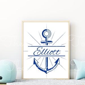 Peut inclure: Une impression encadr&eacute;e blanche avec une ancre bleue et le nom "Elliott" en police bleue marine. L'ancre est entour&eacute;e d'un &eacute;clat de rayons.