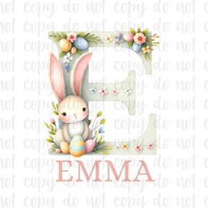 May include: A light blue letter E with a white bunny holding an Easter egg. The letter is decorated with pastel flowers and eggs. The name "EMMA" is written in pink below the letter.