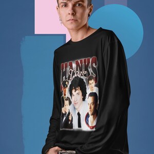 Puede incluir: Camiseta negra de manga larga con un gráfico de estilo vintage con Tom Hanks y el texto "Hanks Tom".