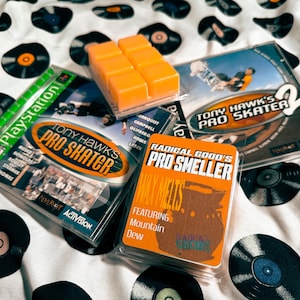 May include: An assortment of items including video games and wax melts. The video games are "Tony Hawk's Pro Skater" for PlayStation and "Tony Hawk's Pro Skater 2". The wax melts are orange and labeled "Radical Good's Pro Smeller".