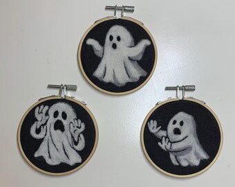 Needle felted ghost. Halloween decor “painted” with wool on linen and mounted in 3 inch embroidery hoop.