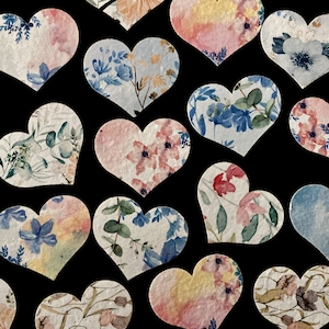 May include: Assortment of heart-shaped paper confetti with floral and watercolour designs in shades of blue, pink, and green.