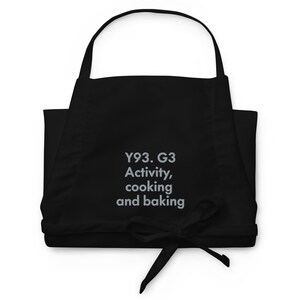 May include: Black apron with the text "Y93. G3 Activity, cooking and baking" embroidered in gray.