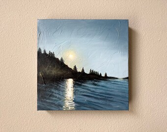 May include: A painting of a dark blue lake with a sliver of a bright yellow sun shining through the clouds. The lake is surrounded by a dark green forest and a rocky shoreline.