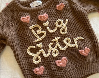 Broderie à la main sur un pull en tricot pour enfants