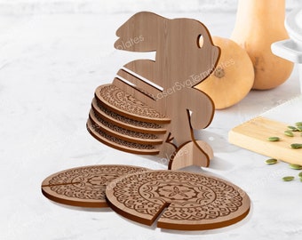 May include: Wooden coaster set with a bunny-shaped holder. The coasters feature a mandala design and are stacked in the holder.