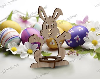 May include: Wooden bunny rabbit Easter egg holder with a round base. The bunny is holding its arms out and has a smiling face. The holder is surrounded by colourful Easter eggs with floral designs.