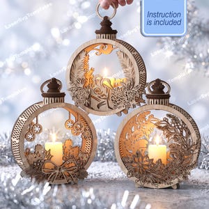 May include: Three circular laser-cut wooden ornaments featuring intricate holiday designs, each holding a lit pillar candle. The designs include a nativity scene, hanging ornaments, and floral motifs. A blue box states Instruction is included.