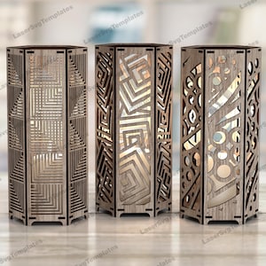 May include: Three wooden lamps with geometric patterns. Each lamp has a different design, including squares, zigzags, and circles. The lamps are made of light-coloured wood and emit a warm glow. The lamps are approximately 30 cm tall.