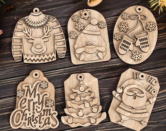 Könnte beinhalten: Sechs Weihnachtsornamente aus Holz mit verschiedenen Designs. Die Ornamente zeigen ein Rentier, das einen Pullover trägt, einen Pinguin, der eine Tasse hält, Fäustlinge, einen Weihnachtsbaum, einen Weihnachtsmann und die Worte "Frohe Weihnachten".