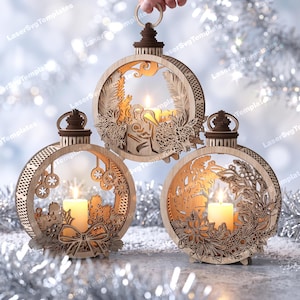 Könnte beinhalten: Drei kreisförmige Ornamente aus hellem Holz mit komplizierten lasergeschnittenen Motiven wie Tannenzweigen, Beeren und Schleifen. Jedes Ornament enthält in der Mitte eine kleine, brennende weiße Stumpenkerze.