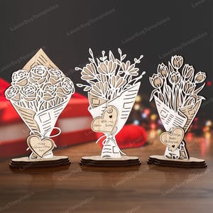May include: Three wooden laser-cut bouquets of flowers, each in a paper wrap, stand on a wooden base. The bouquets feature roses, mixed flowers, and tulips. Each bouquet has a heart-shaped tag with a message.