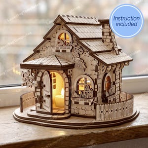 May include: A wooden miniature house with a stone-like facade, arched windows, and a chimney. The house features a decorative fence, a front door, and a lit candle inside. The text "Instruction included" is in a blue circle.