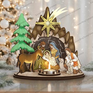 May include: A wooden Christmas nativity scene with a star, figures, and a candle. The scene includes a donkey, a green tree, and figures of Mary, Joseph, and baby Jesus. The star is gold and the figures are painted with various colors.