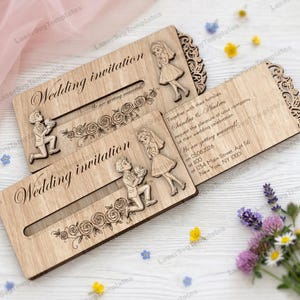 May include: Wooden wedding invitation with laser-cut design. The invitation features the words "Wedding invitation" and "We are getting married!" along with a floral design and illustrations of a couple. The invitation is open, revealing the wedding details.