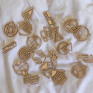 May include: A collection of 17 wooden geometric shapes with intricate designs. The shapes are cut from wood and have a natural finish. They are perfect for crafting, scrapbooking, or home decor.
