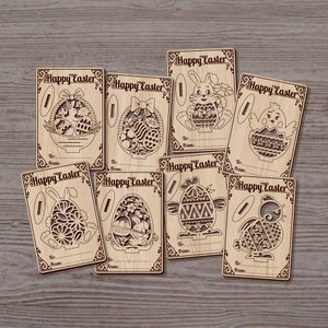 May include: Eight laser-cut wooden cards with a Happy Easter greeting and various Easter-themed designs, including bunnies, chicks, and eggs. Each card has a space for a name and a message.